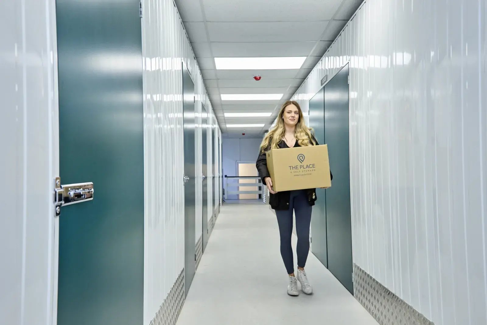 the-place-4-self-storage-customer-moving-box-to-secure-lock-up-unit-1600x1067