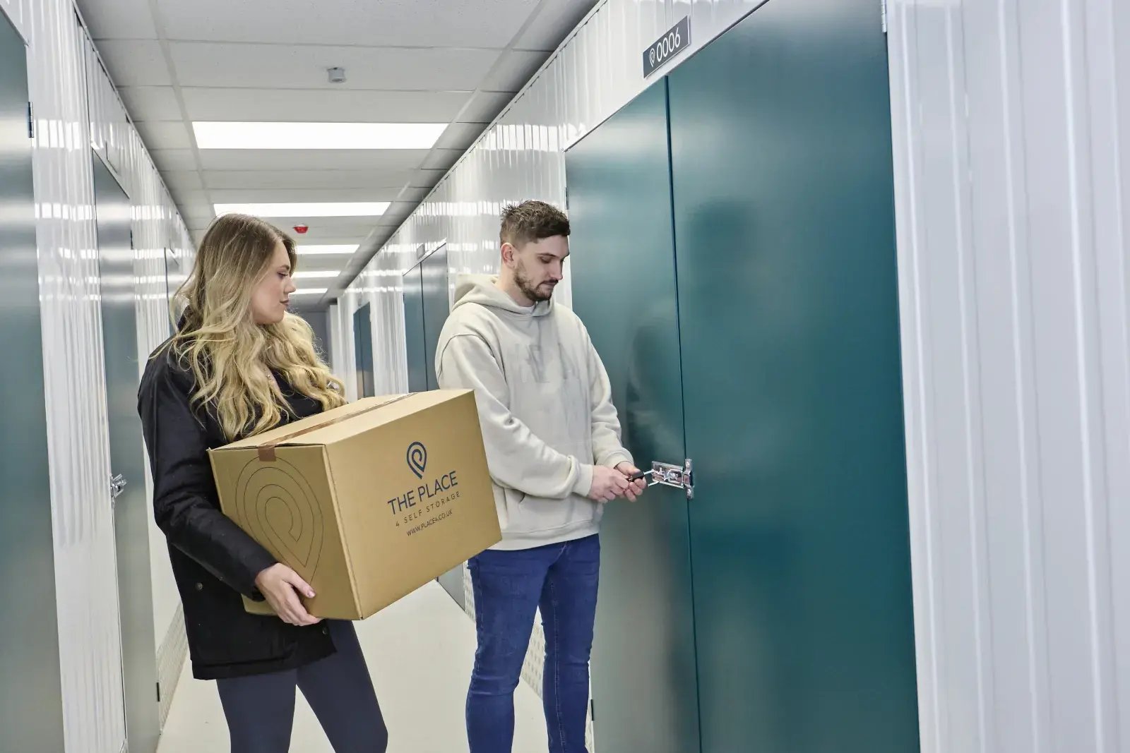 the-place-4-self-storage-customers-with-packed-box-unlocking-storage-unit-1600x1067