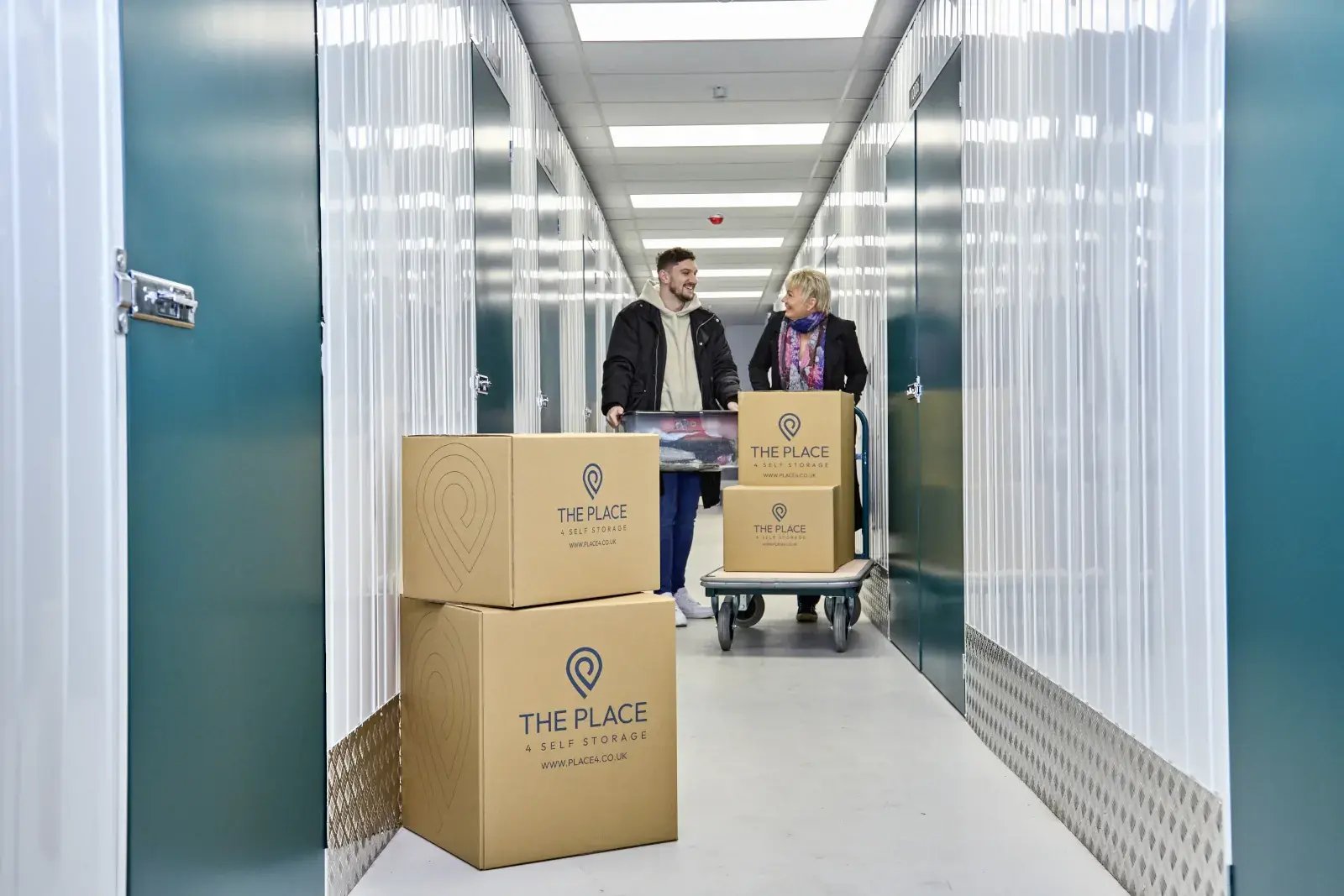 the-place-4-self-storage-customers-with-packed-boxes-in-corridor-and-on-trolley-1600x1067