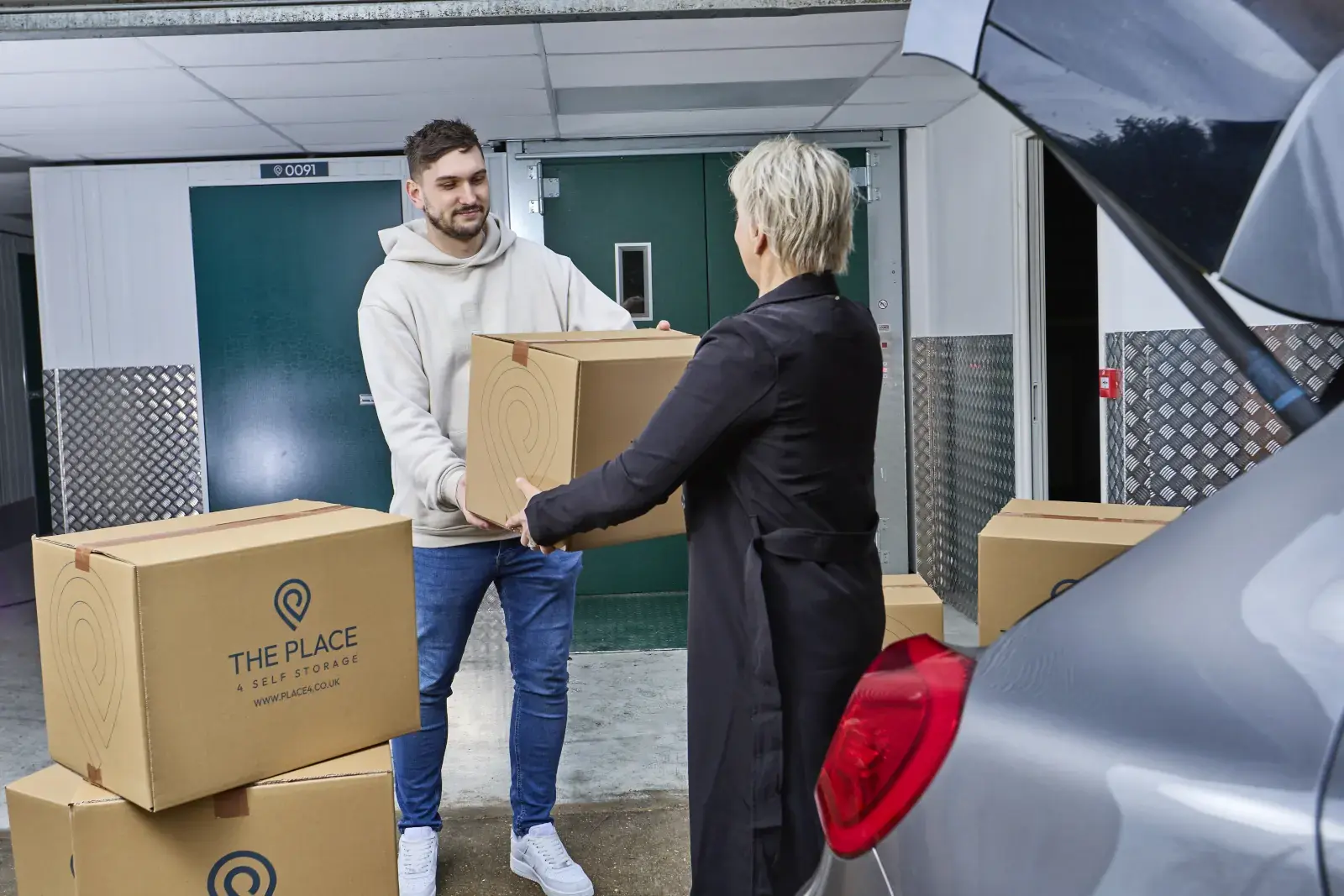 the-place-4-self-storage-customers-unloading-packed-boxes-from-car-together-1600x1067