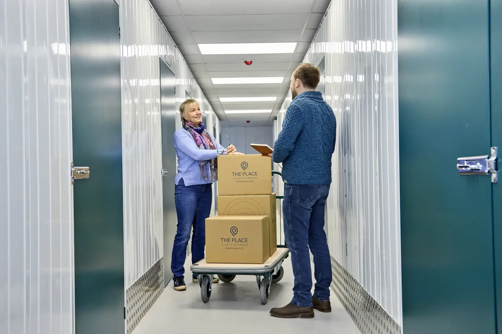 the-place-4-self-storage-customers-with-loaded-trolley-on-way-to-unit-1600x1067