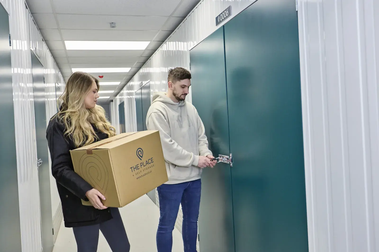 the-place-4-self-storage-customers-with-packed-box-unlocking-storage-unit-1600x1067