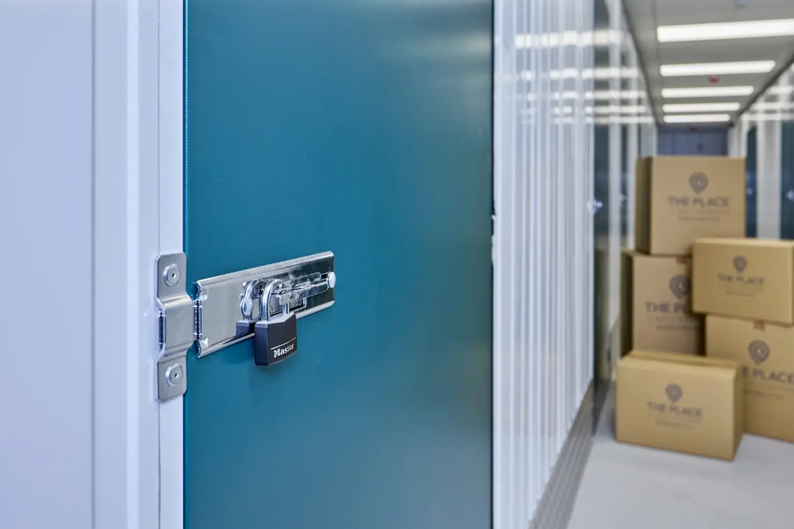 the-place-4-self-storage-locked-unit-door-with-branded-boxes-in-background-1600x1067