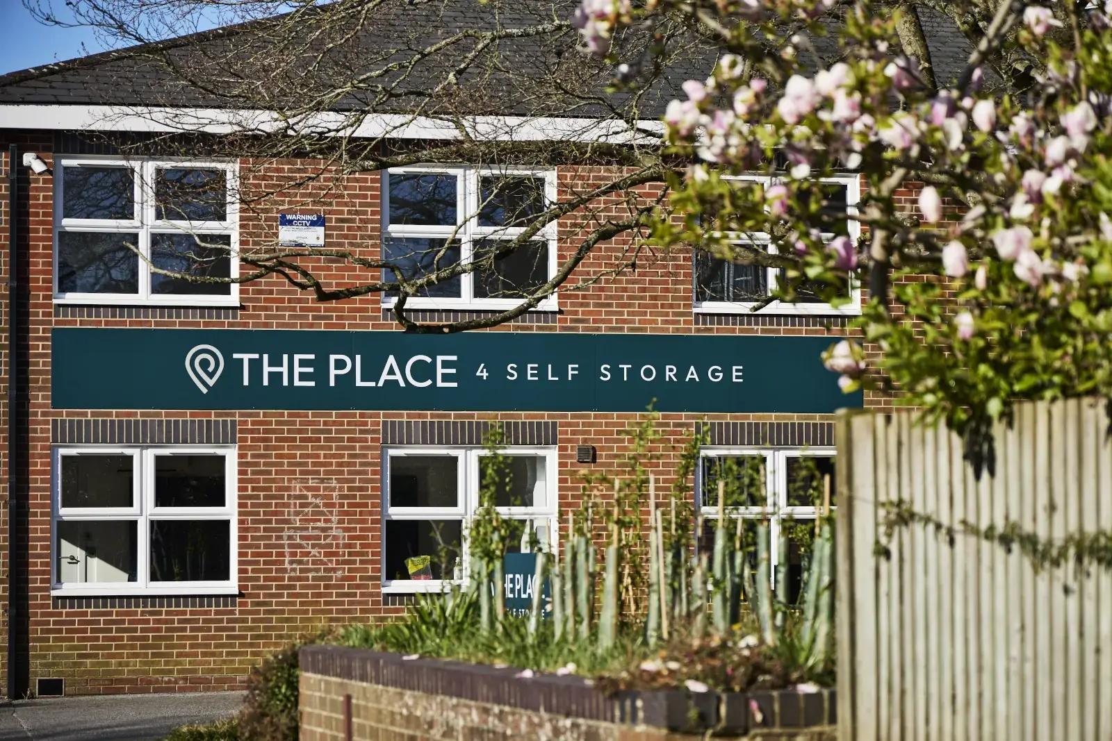 the-place-4-self-storage-petersfield-branded-building-exterior-through-blossom-1600x1067